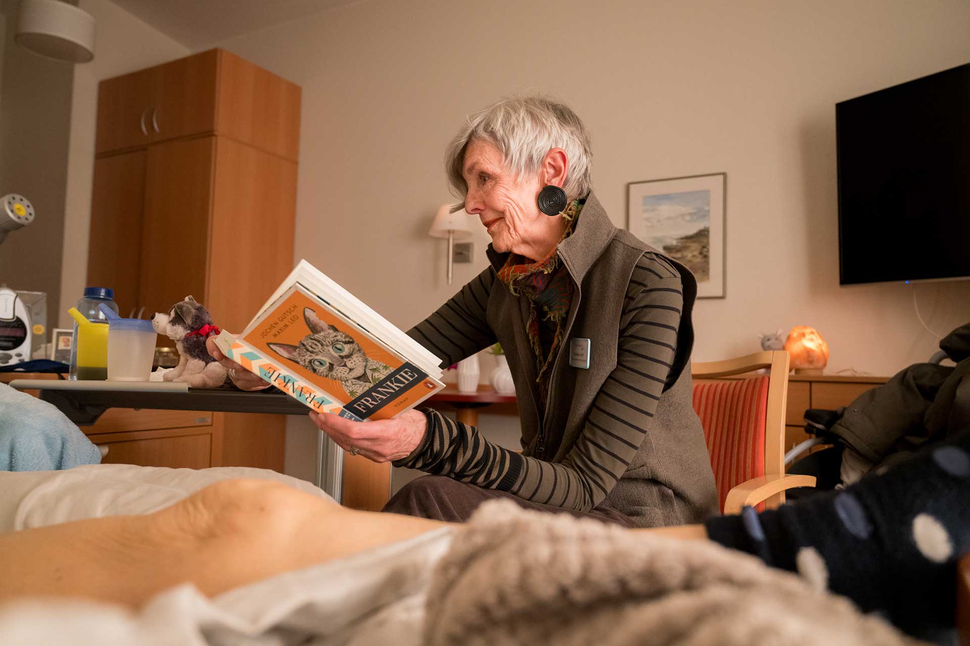 Ricam Hospiz Ehrenamt Ricam Hospiz Ehrenamt - Eine Dame liest aus einem Buch vor